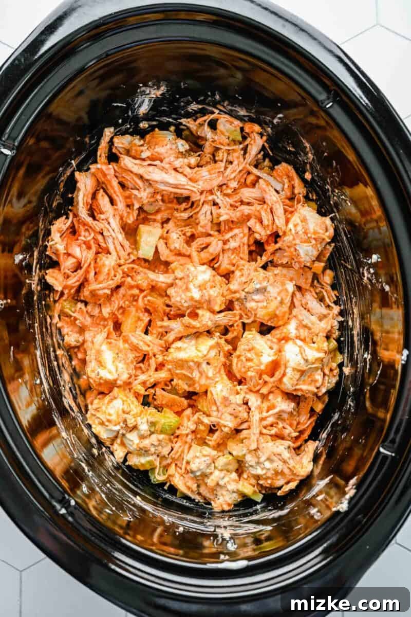 Crockpot buffalo chicken dip is the perfect party snack. It's creamy, loaded with chicken, and bursting with blue cheese and buffalo flavor. All ingredients for buffalo chicken dip, including shredded chicken, cream cheese, hot sauce, and blue cheese, are gently mixed together in a slow cooker before cooking.