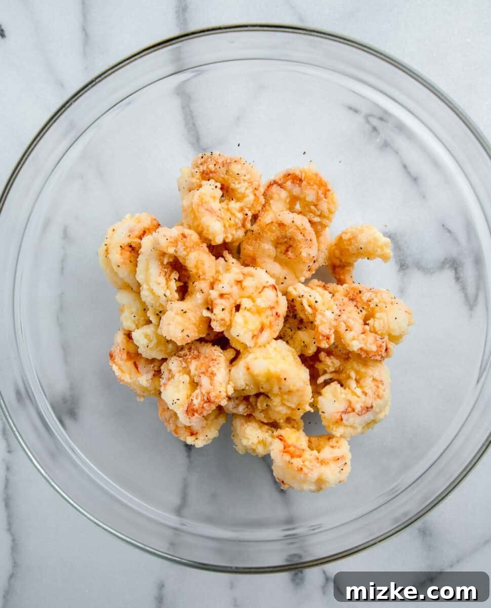 Crispy Honey Walnut Shrimp 11 A generous pile of golden-fried shrimp resting in a clear glass mixing bowl.