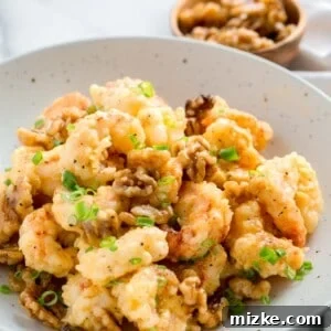 Honey walnut shrimp in a large speckled bowl, garnished with fresh scallions.