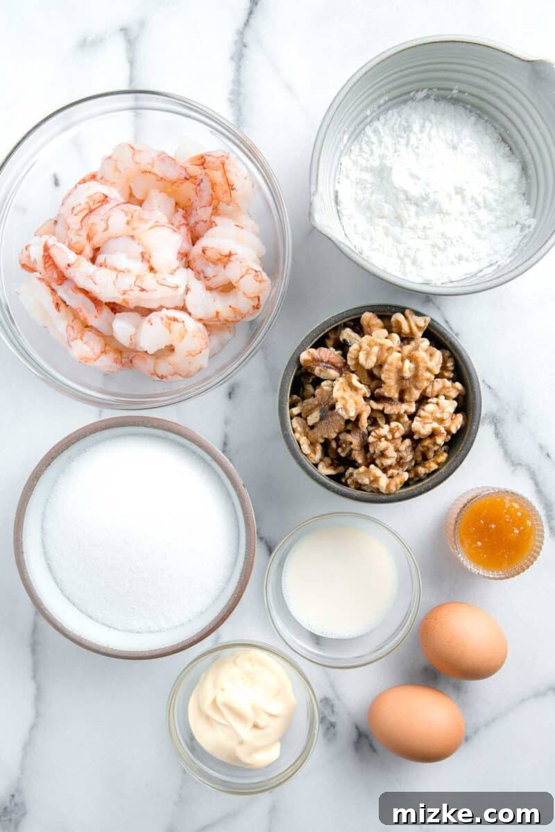 Crispy Honey Walnut Shrimp 4 Ingredients for honey walnut shrimp laid out on a wooden cutting board.