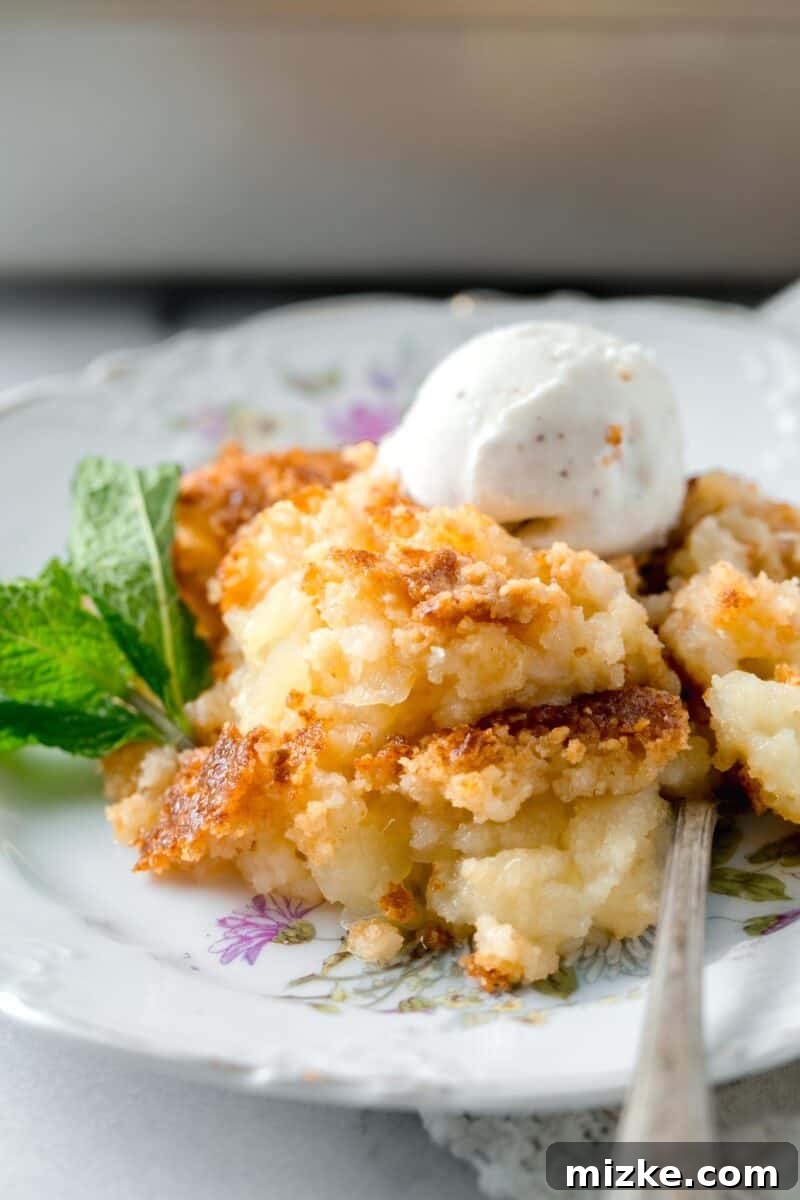 A perfectly baked pineapple dump cake, still in the pan, with a golden brown topping and bubbling fruit around the edges.