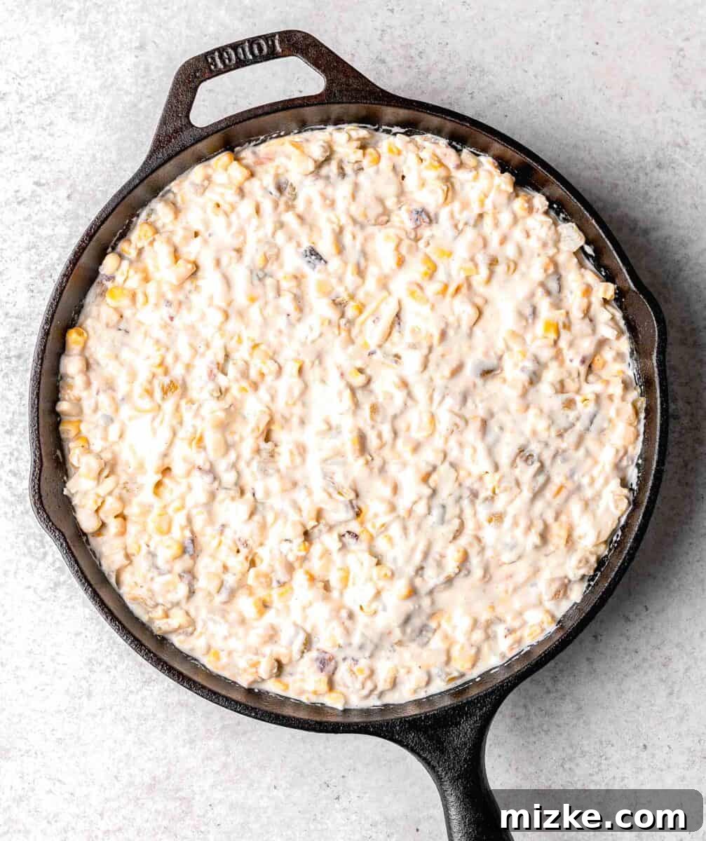 ingredients for corn dip all mixed together in the cast iron skillet