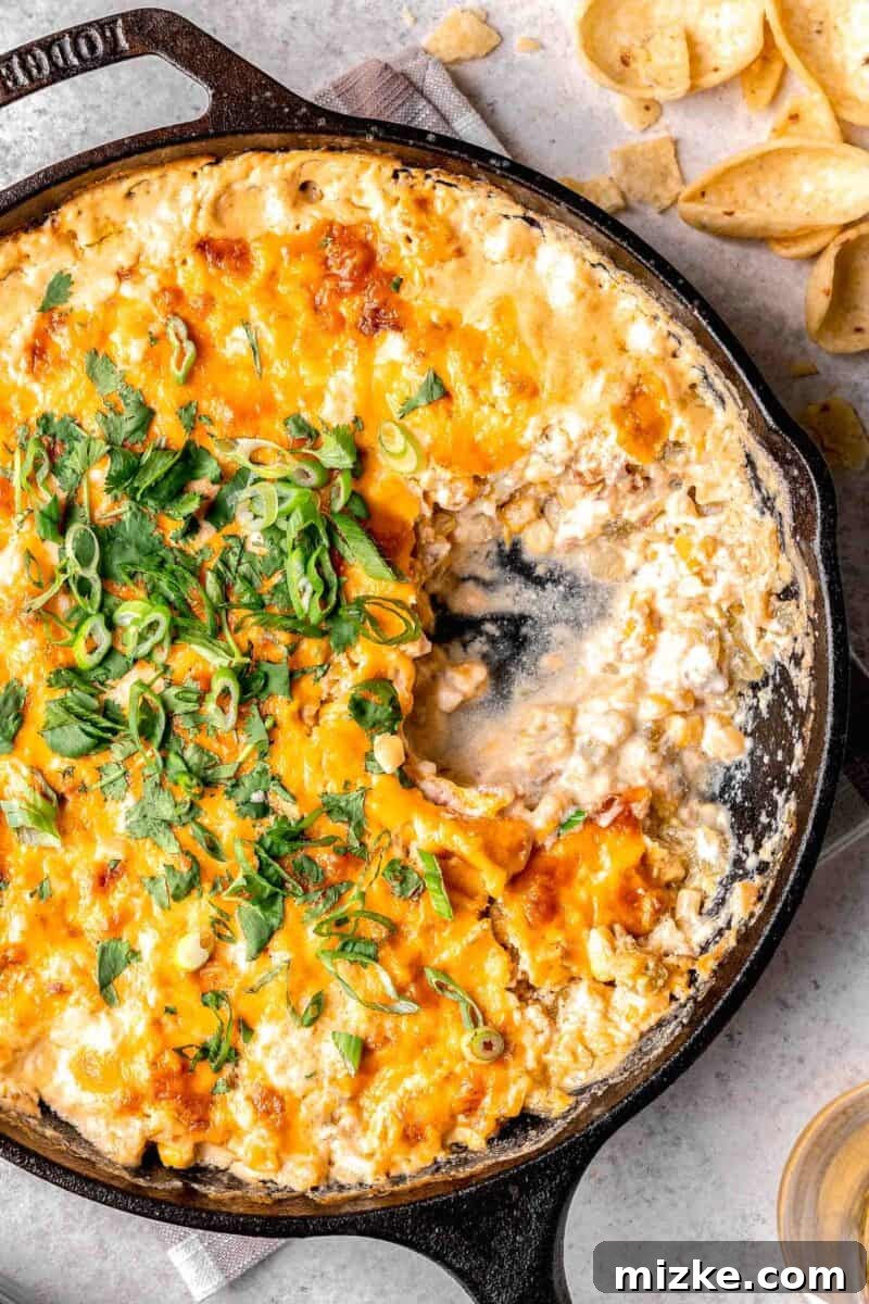 inside of corn dip in a cast iron skillet next to tortilla chips