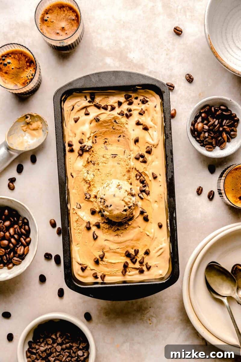 Espresso Chocolate Chip Bliss 2 Rich, creamy homemade espresso chocolate chip ice cream in a loaf pan, surrounded by espresso shots and whole espresso beans, highlighting the coffee theme.