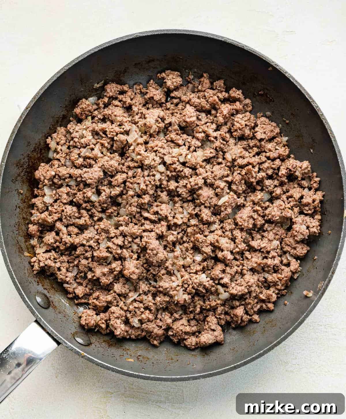Big Mac salad is made up of cooked ground beef tossed together with crispy lettuce and tomatoes in a creamy, thousand islands-esque dressing. Browning ground beef with onions in a skillet.