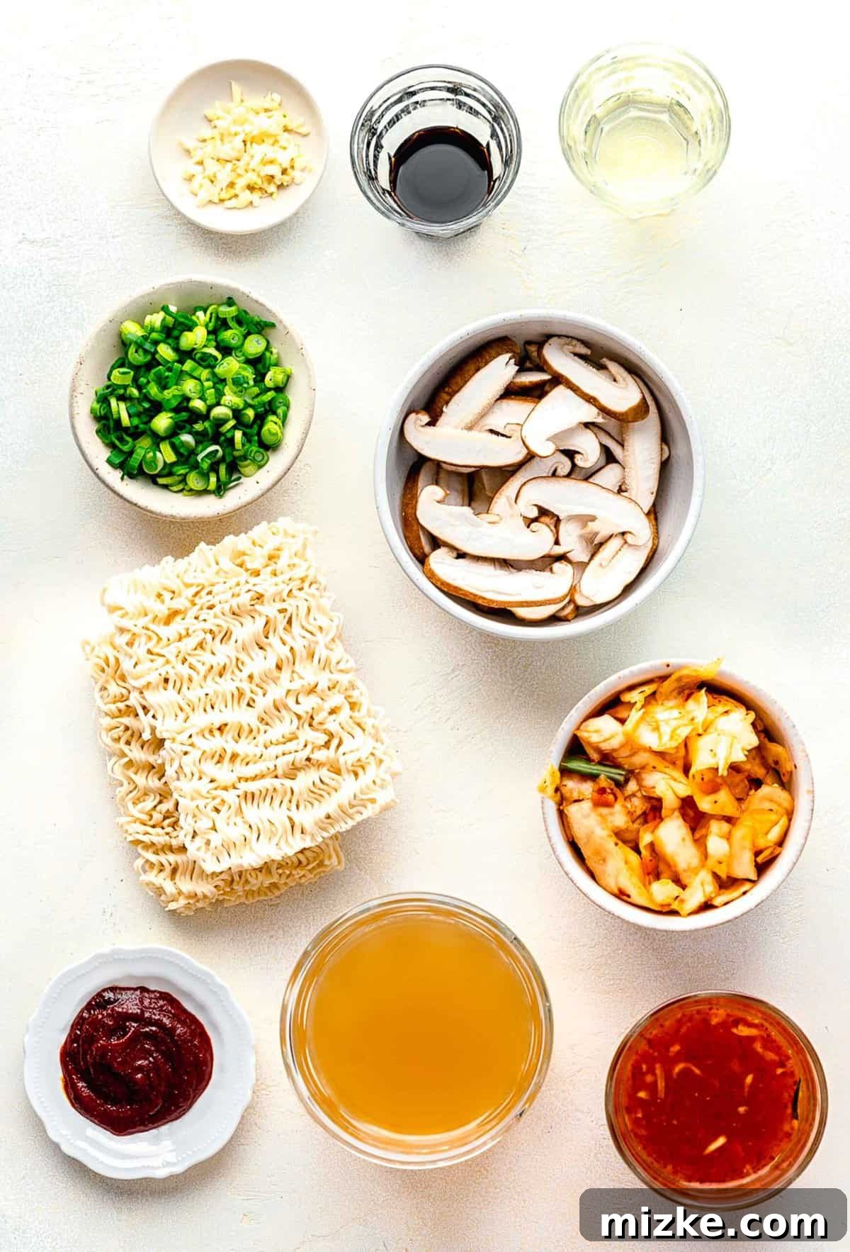Fresh Ingredients Ready for Your Homemade Kimchi Ramen Various ingredients for kimchi ramen, including sliced mushrooms, kimchi, garlic, and green onions, neatly arranged in separate bowls.