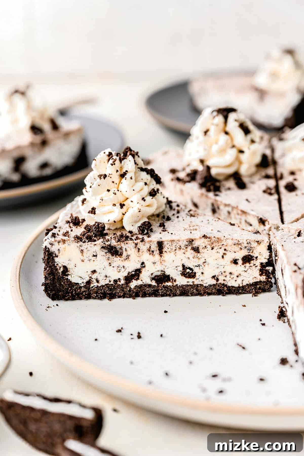 Oreo pie cut into slices on a serving plate, showcasing the creamy filling and crunchy crust.