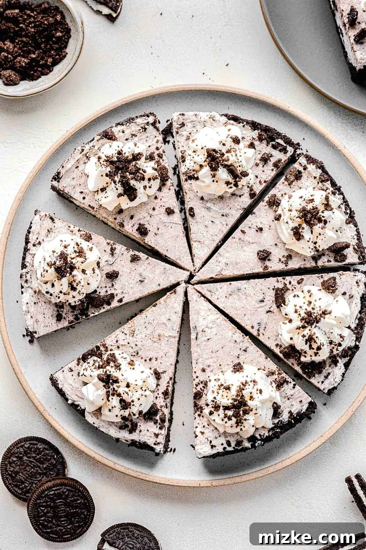Overhead view of a prepared Oreo pie, sliced and served alongside whole Oreos, highlighting its irresistible texture.