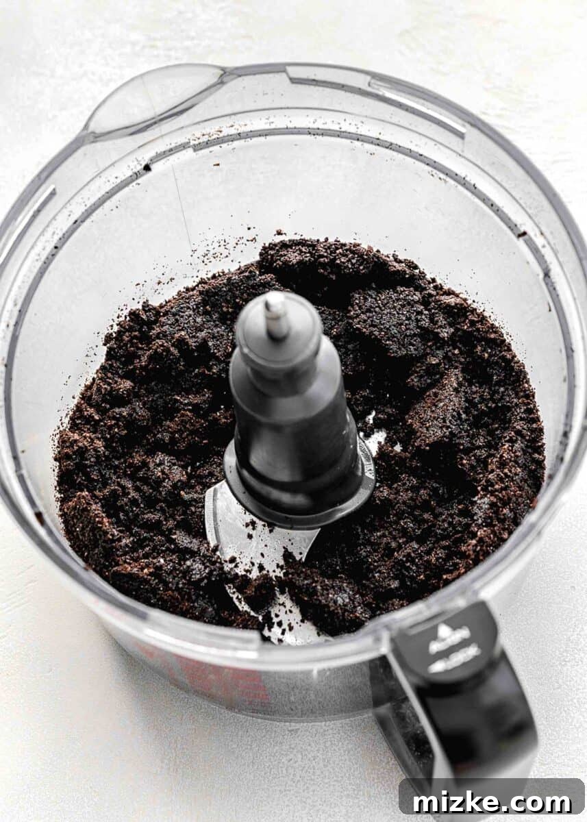 Oreos and melted butter pulsed into fine crumbs in a food processor, ready for the crust.