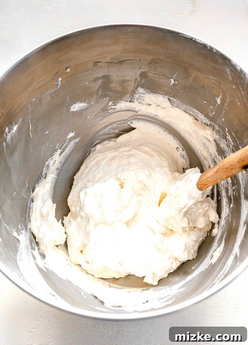 Gently folding whipped cream into the creamy no-bake pie filling to maintain its airy texture.