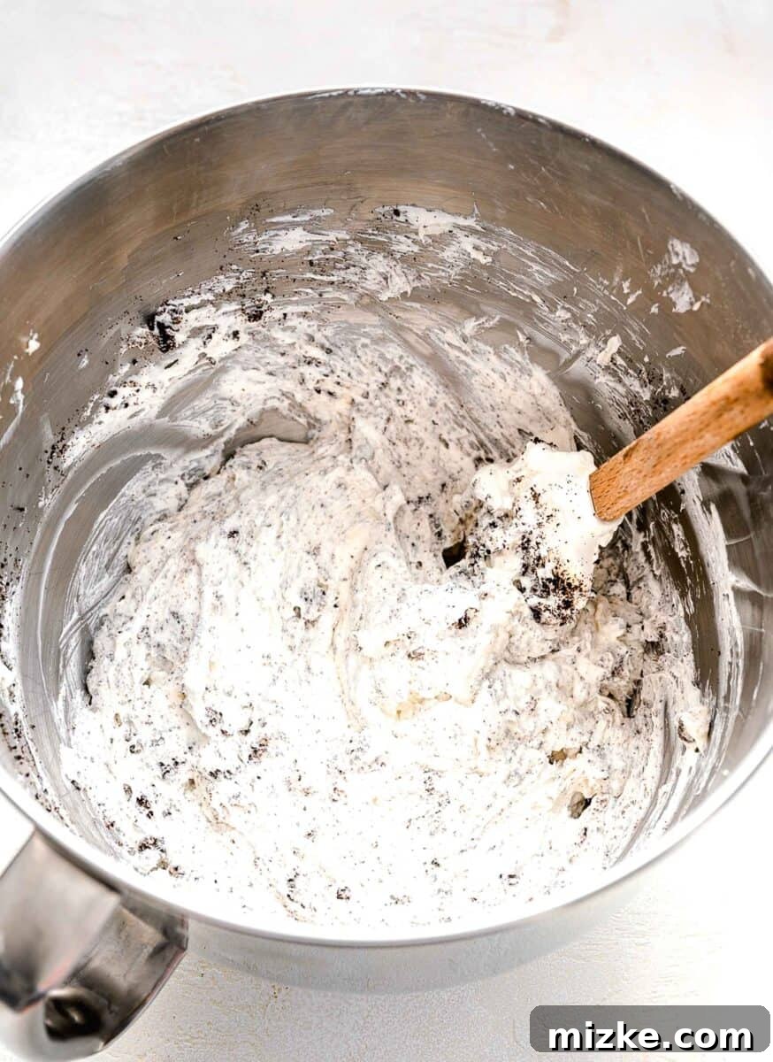 Mixing crushed Oreos into the no-bake pie filling, ensuring even distribution of flavor and texture.