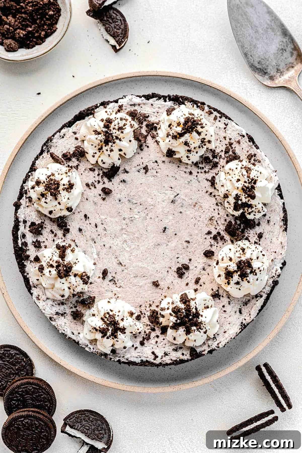 Overhead shot of a beautifully presented Oreo pie on a serving plate, surrounded by whole Oreos.