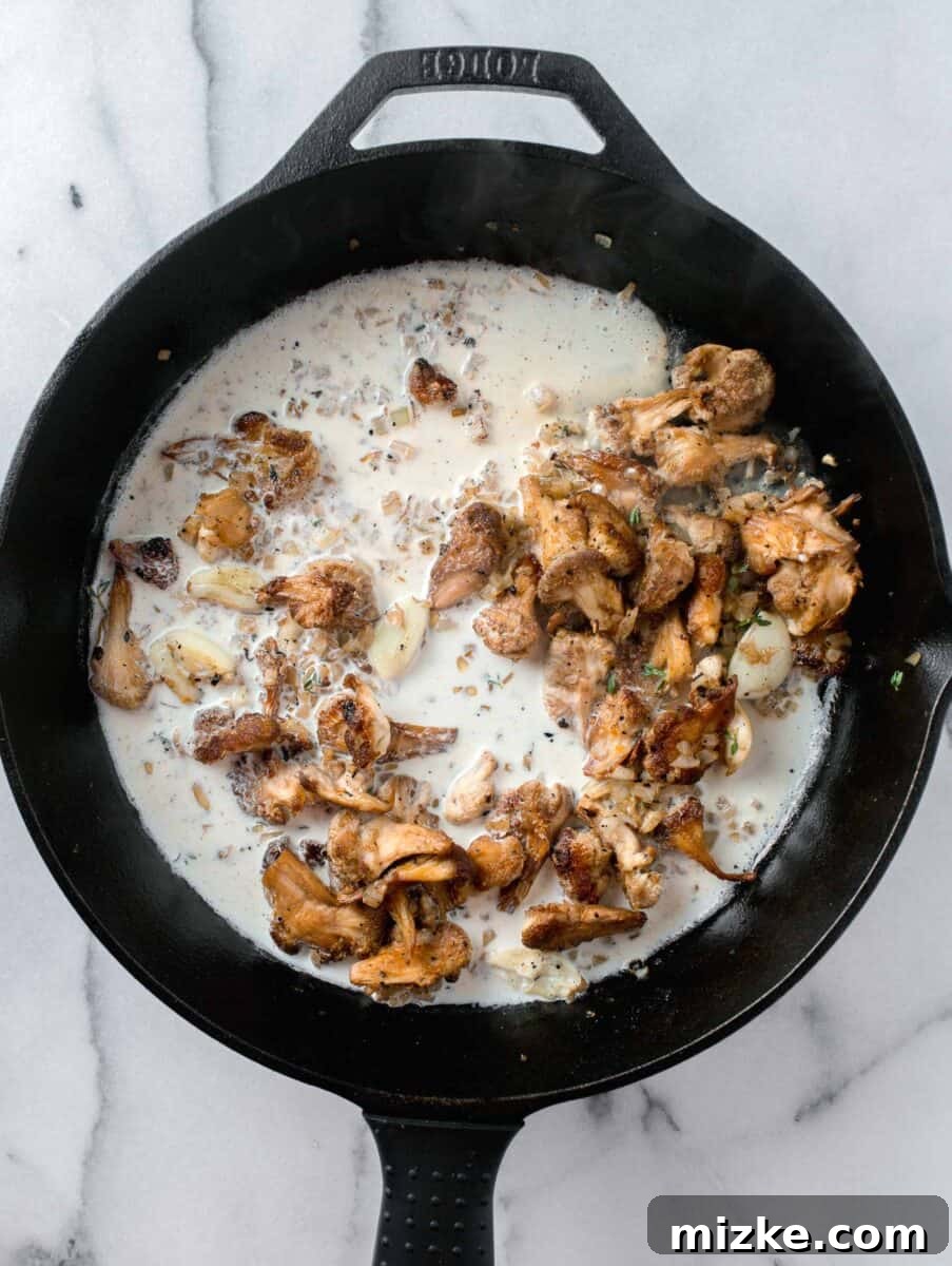 Velvety Lion's Mane Mushroom Pasta 7 heavy cream added into a skillet with lions mane mushrooms, garlic, and onions