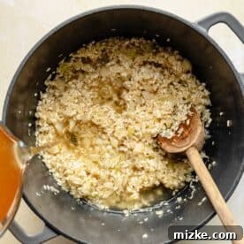 Creamy Shrimp Risotto 4 Adding chicken broth to risotto.