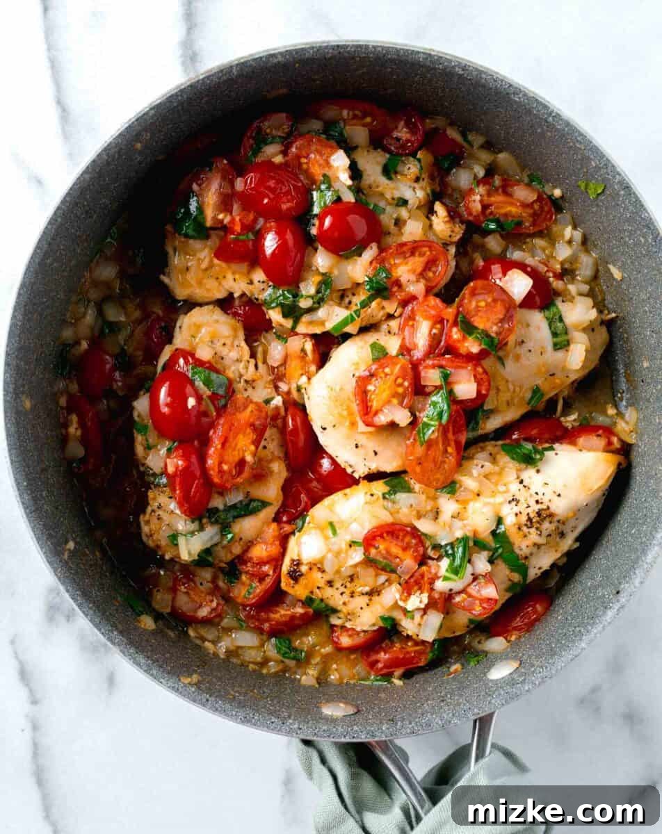 Skillet Roasted Garlic Tomato Basil Chicken 4 one pan garlic tomato basil chicken in skillet with fresh tomatoes, basil, and onions on top of the chicken breasts