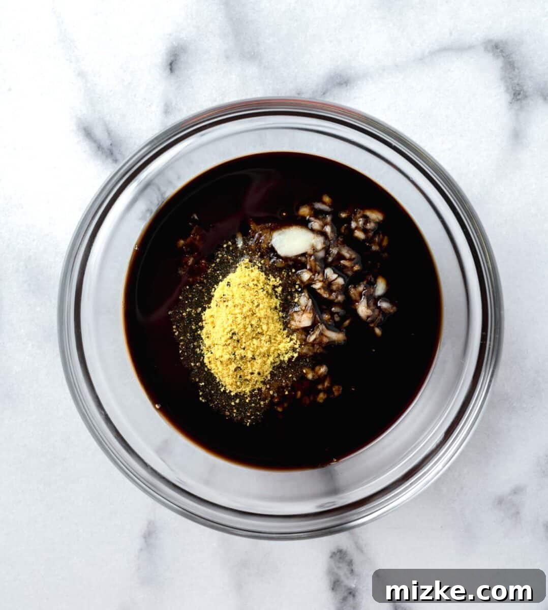 Sauce for honey garlic lemon pepper chicken thighs in a clear bowl
