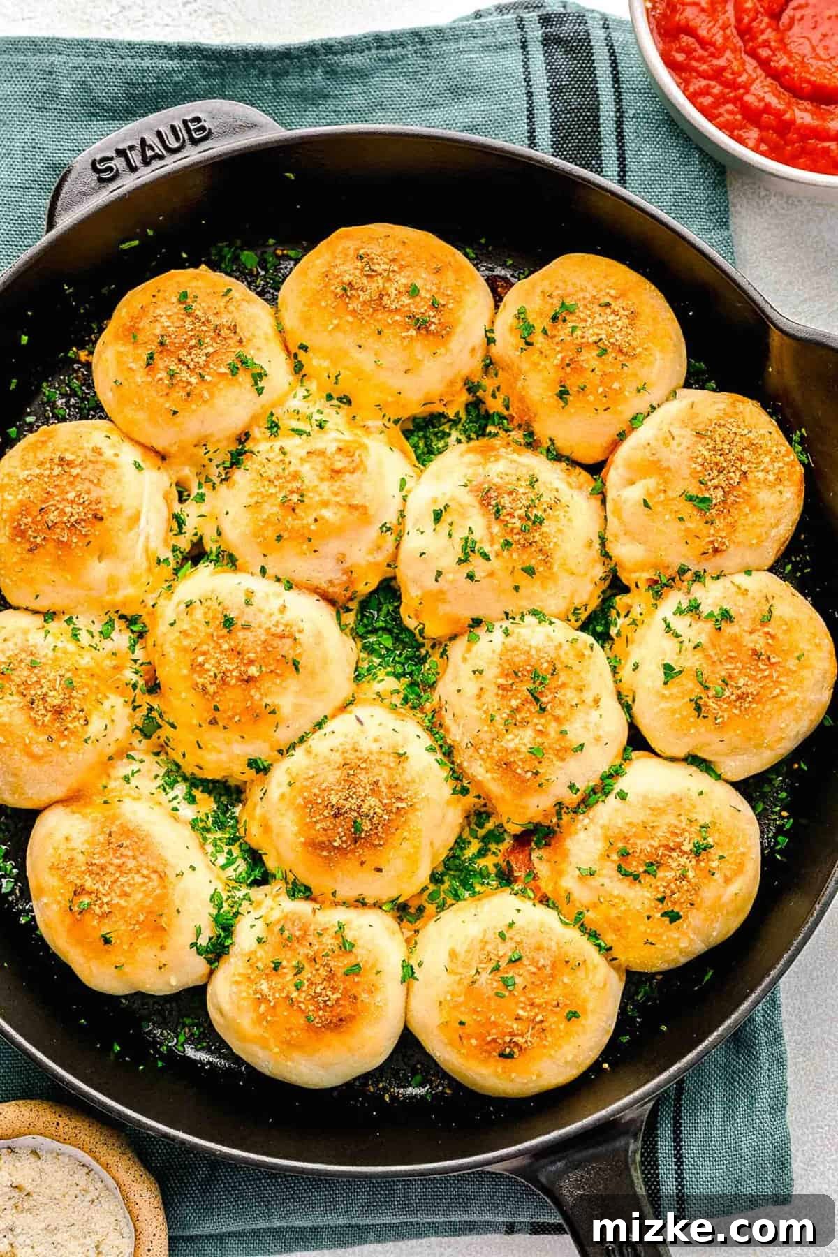 An overhead view of warm pizza bites presented beautifully in a skillet, seasoned and baked to perfection. An inviting overhead view of a skillet full of perfectly baked Stuffed Pepperoni Pizza Balls, glistening and ready to be served.