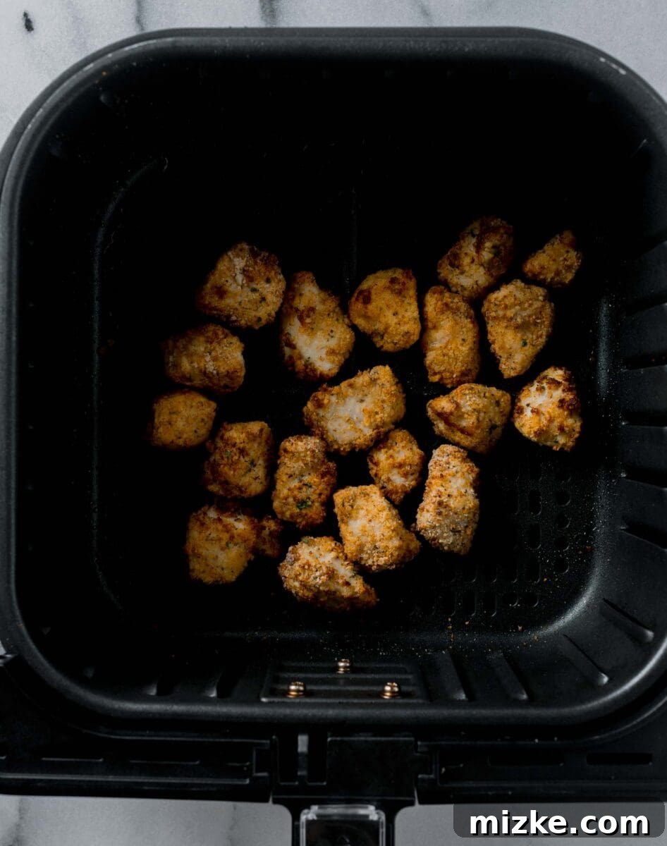 Cooked, golden, and crispy air-fried chicken nuggets perfectly done in the air fryer basket