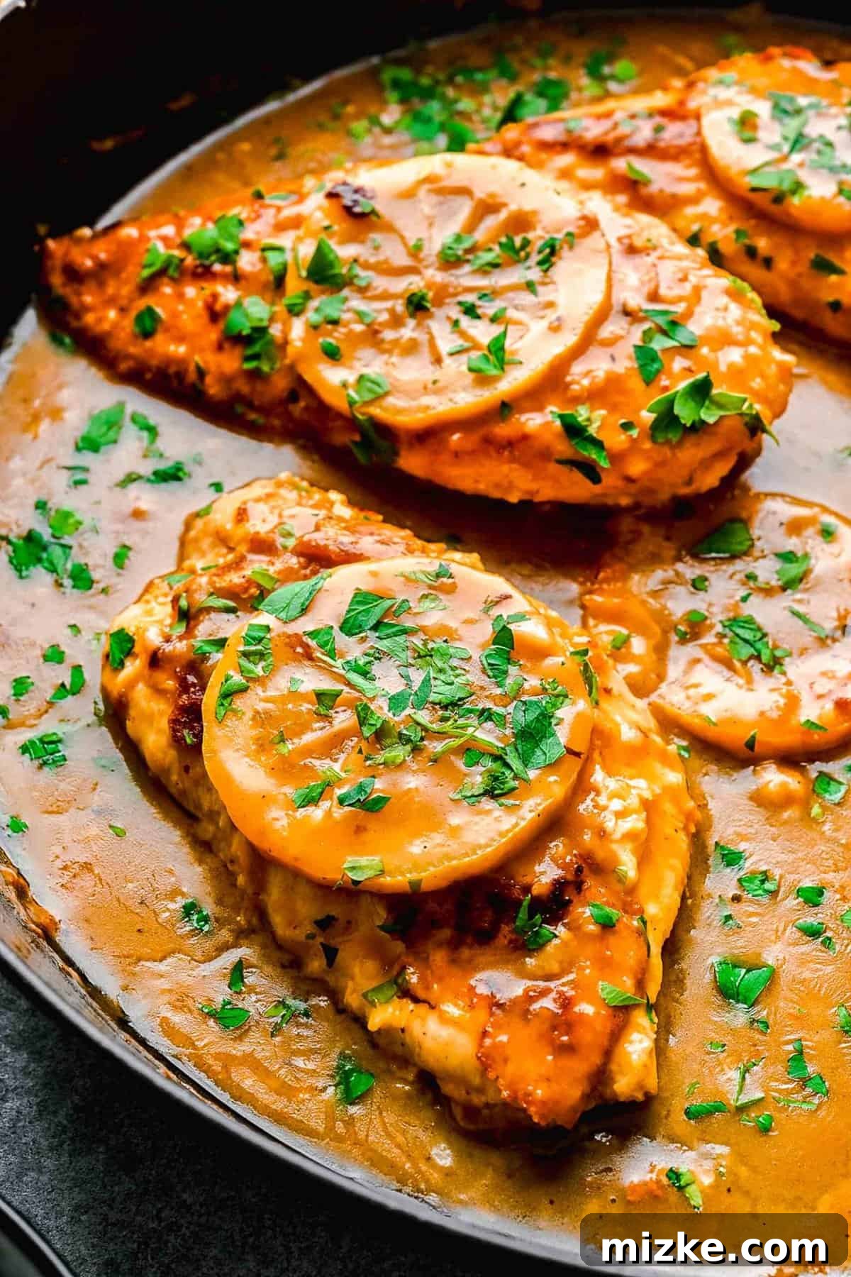 This easy chicken francese is made of tender chicken breast halves lightly breaded, pan-fried, and finished in a bright lemon-butter sauce. Chicken francese in a pan ready to be served.