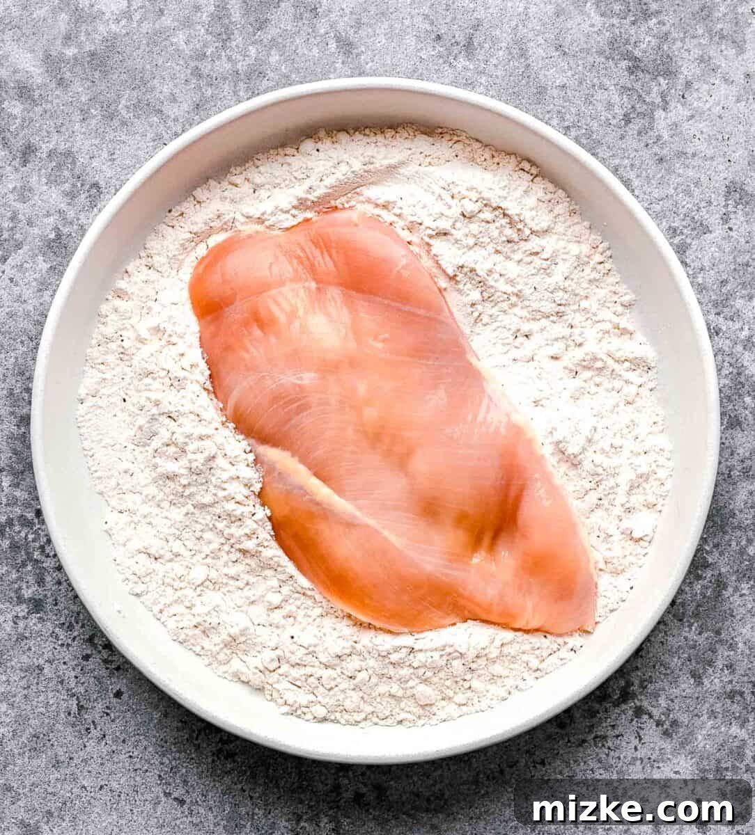 This easy chicken francese is made of tender chicken breast halves lightly breaded, pan-fried, and finished in a bright lemon-butter sauce. Dredging a chicken breast half in seasoned flour.