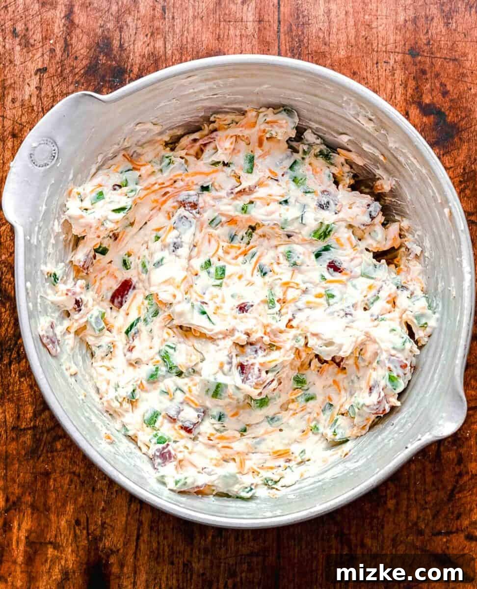 A bowl of fully mixed Jalapeño Popper Dip, showing the vibrant ingredients before baking.