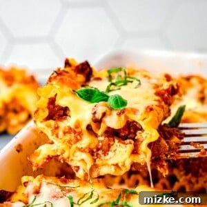 A spatula taking a lasagna roll up out of a baking pan.