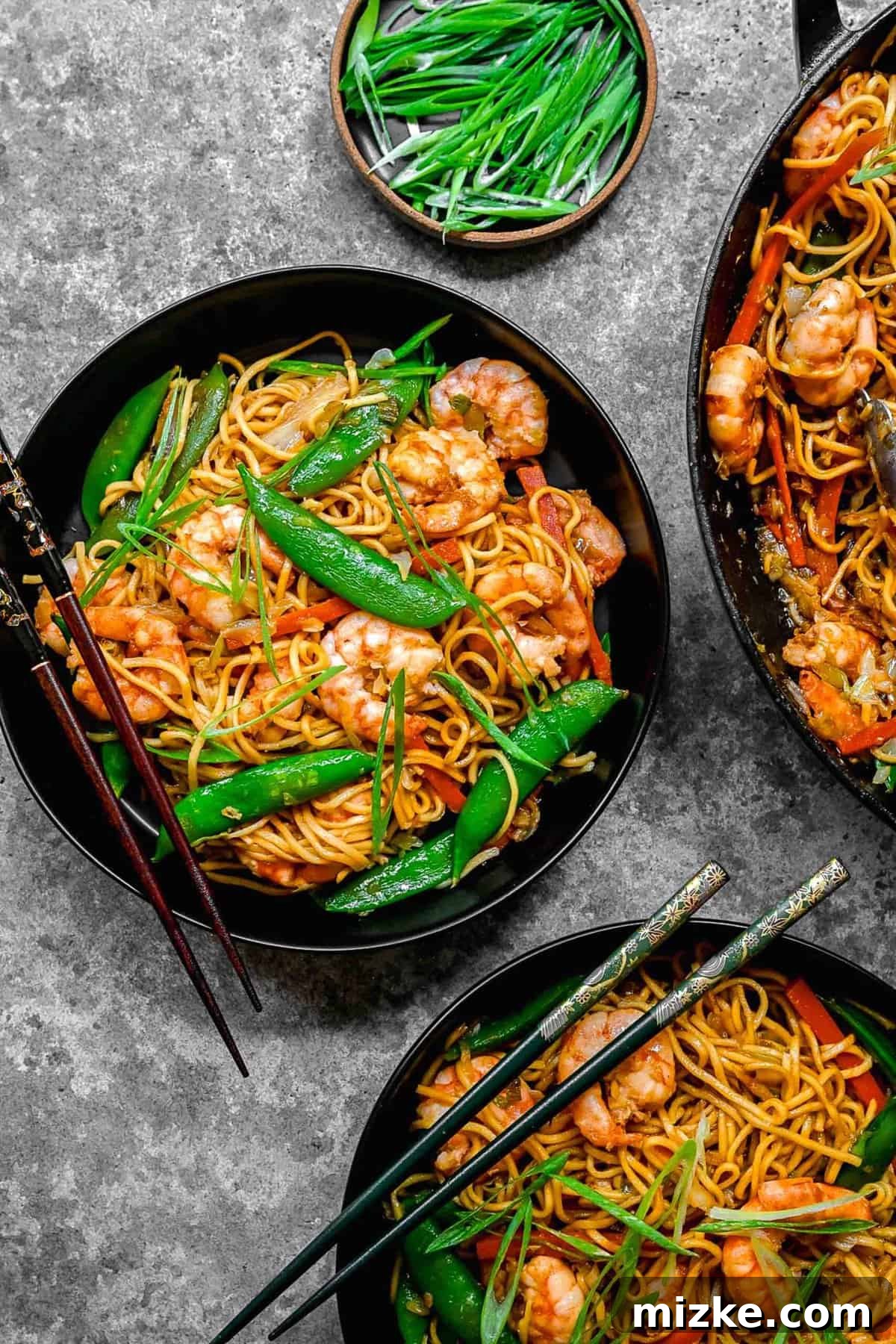 Homemade Shrimp Chow Mein with succulent shrimp, stir-fried veggies, and crisp noodles in a savory sweet sauce. Overhead shot of shrimp chow mein served in bowls with chopsticks, showcasing crisp noodles and fresh ingredients.