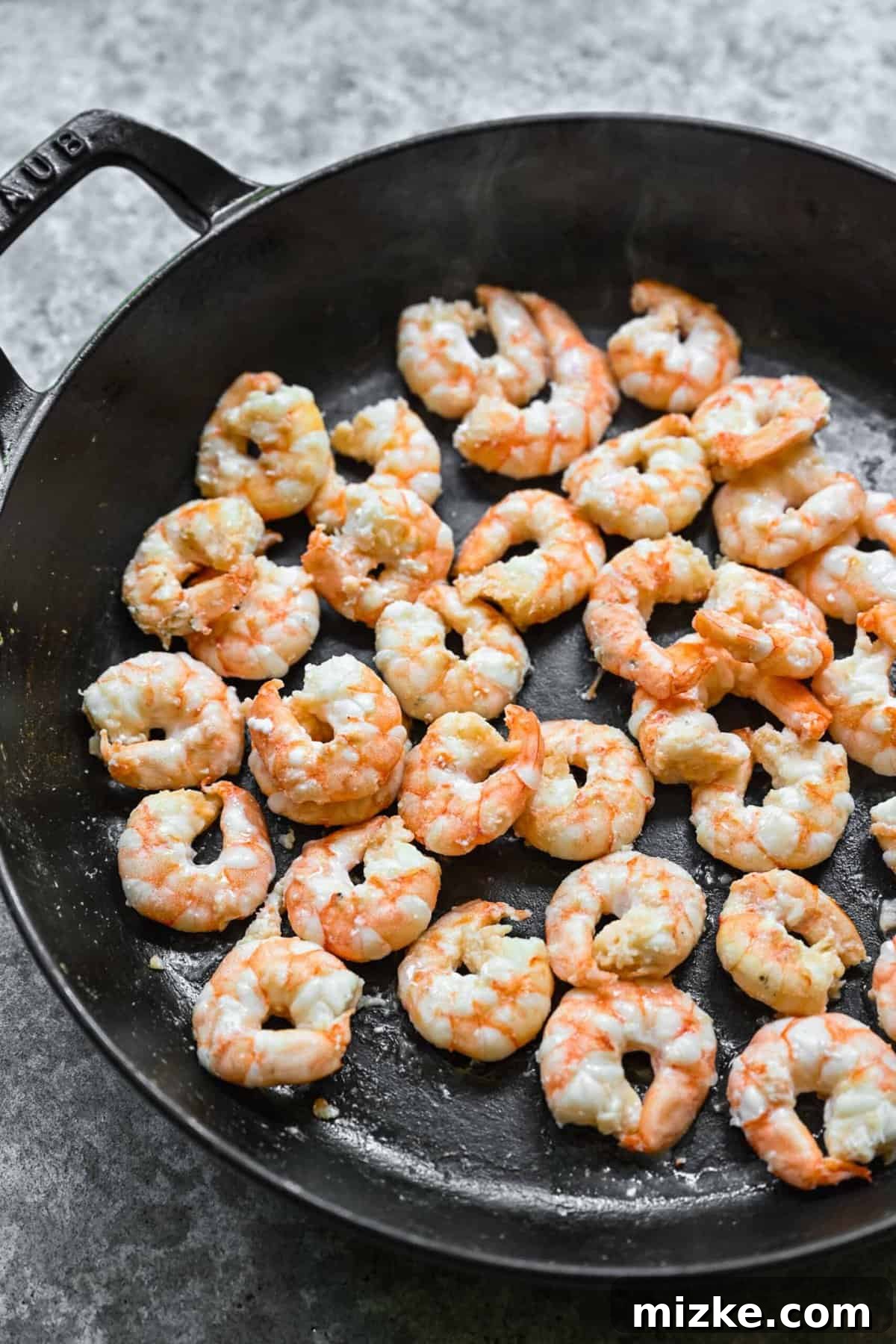 Cooking shrimp to perfection for shrimp chow mein. Sautéing shrimp in a skillet until perfectly pink and cooked.