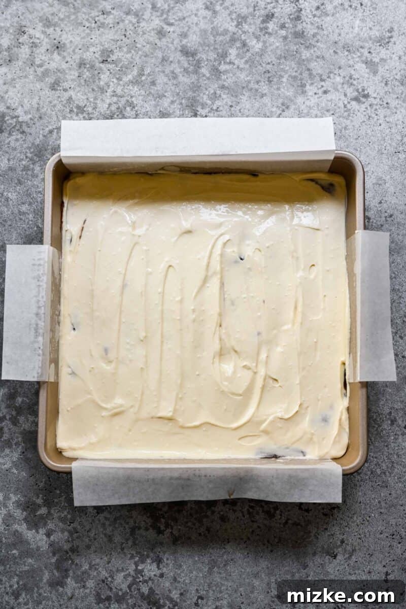Adding a layer of sweetened cream cheese to brownie batter to make cream cheese brownies.