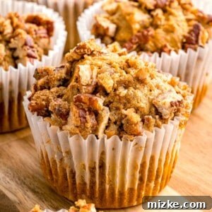 Cozy Pumpkin Pecan Muffins 7 pumpkin pecan muffin in a white muffin liner with chopped pecans on top
