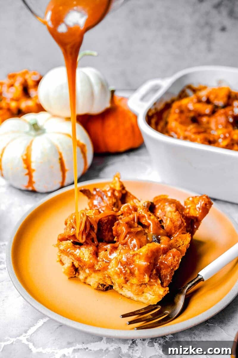 Rich salted caramel sauce being elegantly drizzled over a warm slice of pumpkin bread pudding, served on a vibrant orange ceramic plate, ready to be enjoyed.