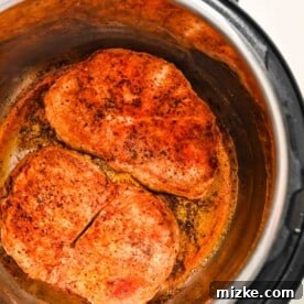 Perfectly Tender Instant Pot Pork Chops 13 Seared pork chops browning in the insert of the Instant Pot