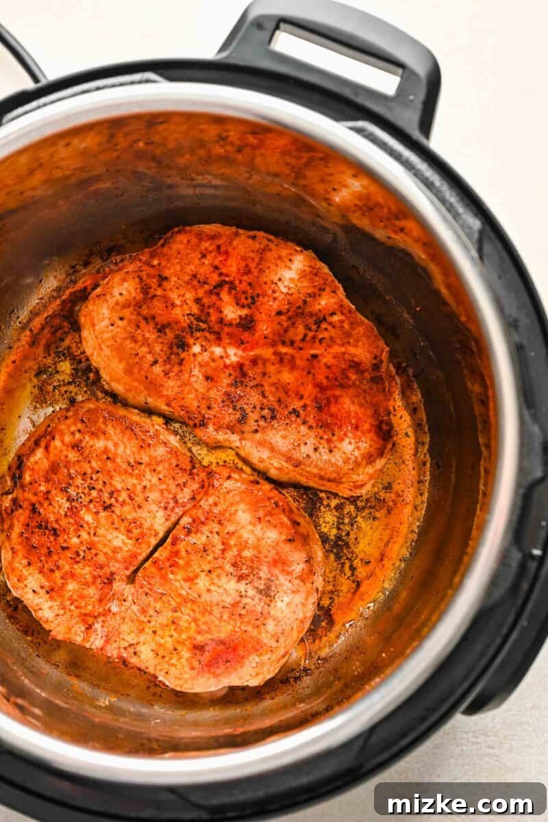 Perfectly Tender Instant Pot Pork Chops 5 Perfectly seared pork chops browning in the insert of the Instant Pot
