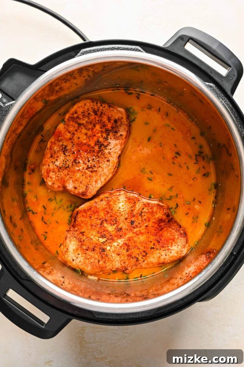 Perfectly Tender Instant Pot Pork Chops 8 Seared pork chops returned to the Instant Pot, submerged in the flavorful liquid before pressure cooking