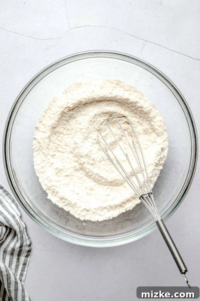dry ingredients for lemon blueberry cupcakes with a whisk in a clear bowl