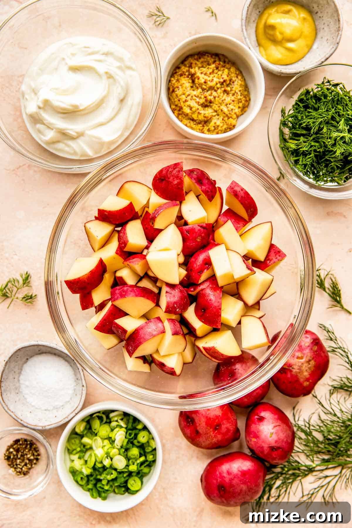 Zesty Dill Potato Salad 3 Fresh ingredients for creamy dill potato salad, including red potatoes, Greek yogurt, green onions, and a bundle of fresh dill, neatly arranged on a kitchen countertop.