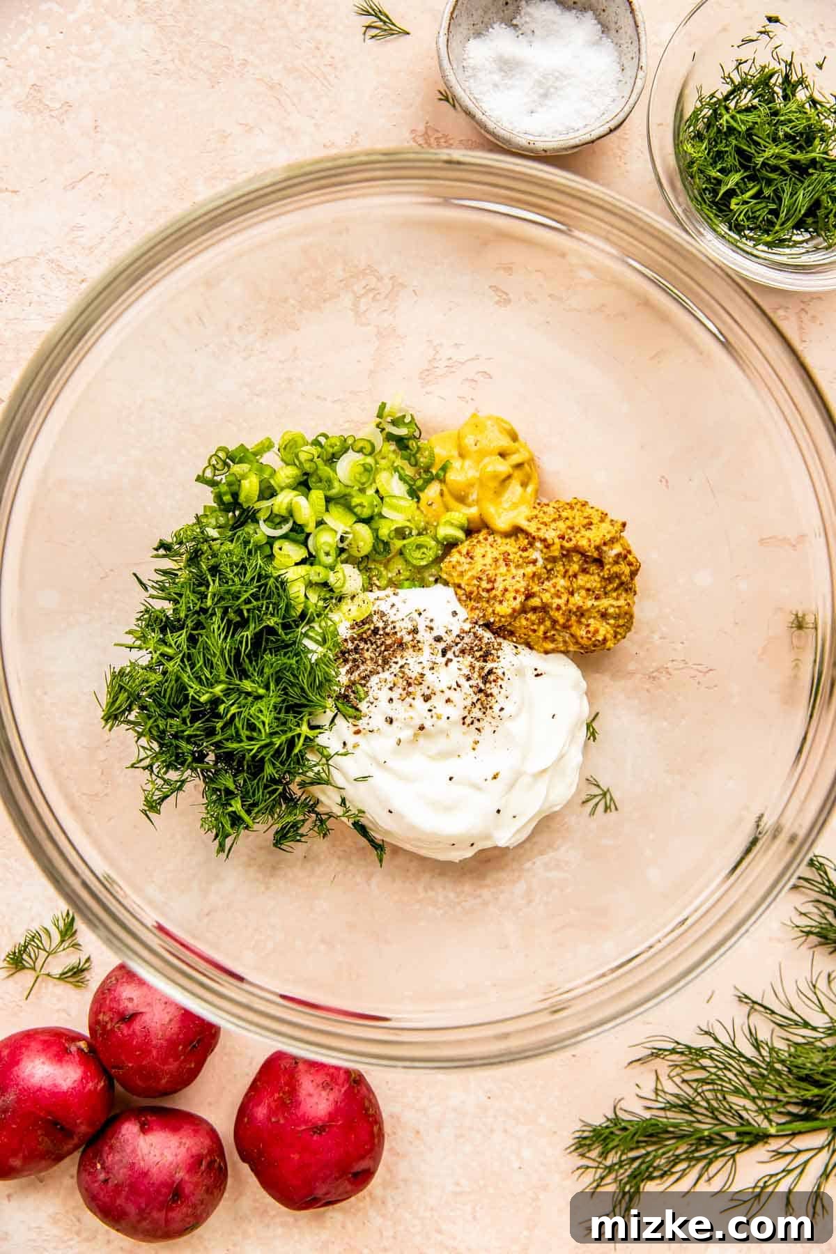 Zesty Dill Potato Salad 4 All the creamy dressing ingredients, including Greek yogurt, mustards, and dill pickle juice, are combined in a mixing bowl.