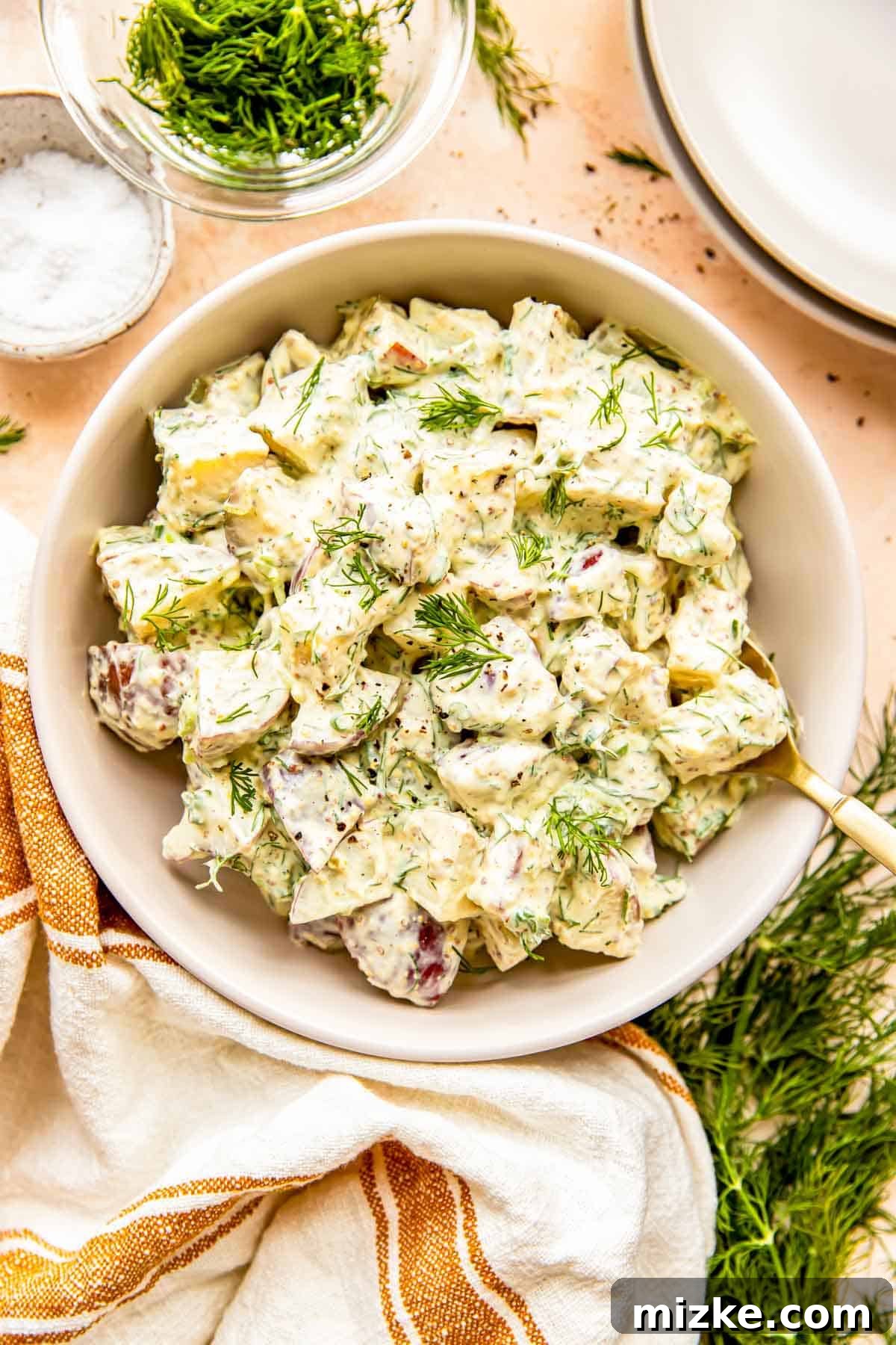 Zesty Dill Potato Salad 8 A vibrant, large bowl filled with freshly prepared dill potato salad, garnished with extra dill, glistening and ready to serve.