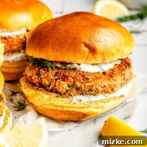 Crispy Air Fryer Salmon Burgers 9 golden brown air fryer salmon burgers nestled in brioche buns, served with lemon wedges and a side of lemon dill mayo.