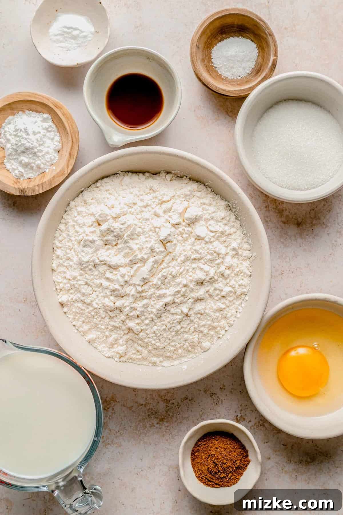 Gathering the simple ingredients to create irresistible pumpkin spice pancakes – light, fluffy, and brimming with aromatic fall flavors. A rustic overhead shot displaying all the essential ingredients neatly laid out on a wooden surface, ready for making pumpkin spice pancakes.