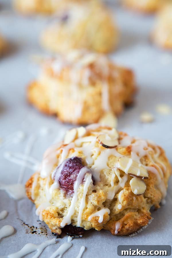 Cherry Almond Scones | tablefortwoblog.com Close-up of a single cherry almond scone with a perfect crumb and glaze.
