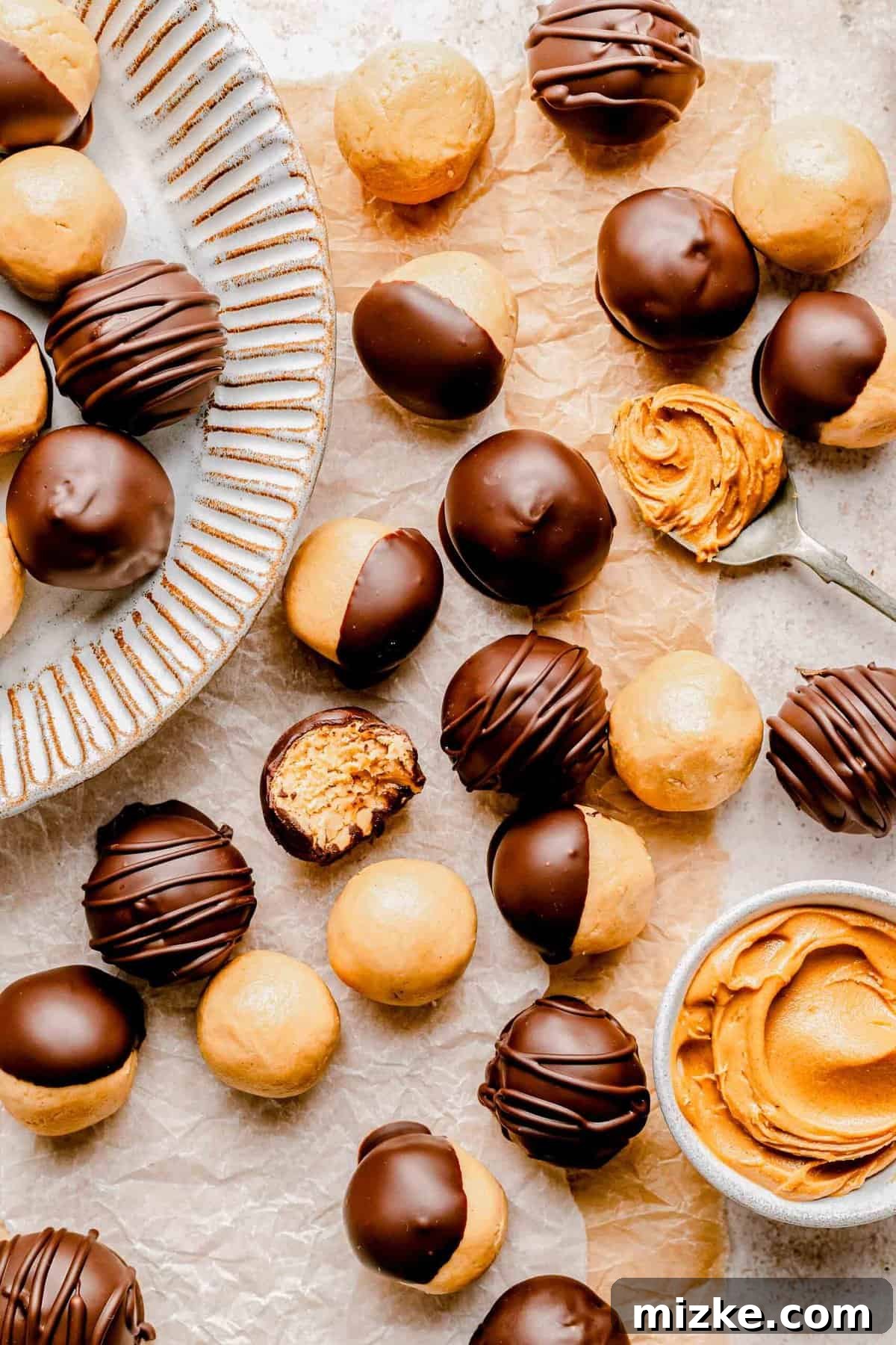 Creamy peanut butter sweetened with powdered sugar is rolled into balls and coated in chocolate to make these decadent peanut butter balls. A close-up overhead shot of multiple chocolate-covered peanut butter balls, showcasing their smooth chocolate coating and uniform size.
