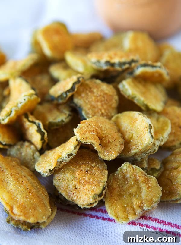 Best Fried Pickles Recipe | tablefortwoblog.com Platter of homemade fried pickles with dipping sauce