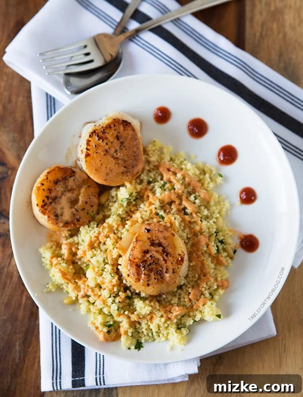 Spicy Curry Scallops on a Bed of Sesame Couscous Close-up of Scallops with a rich Spicy Curry Sauce, showcasing the creamy texture and inviting colors.