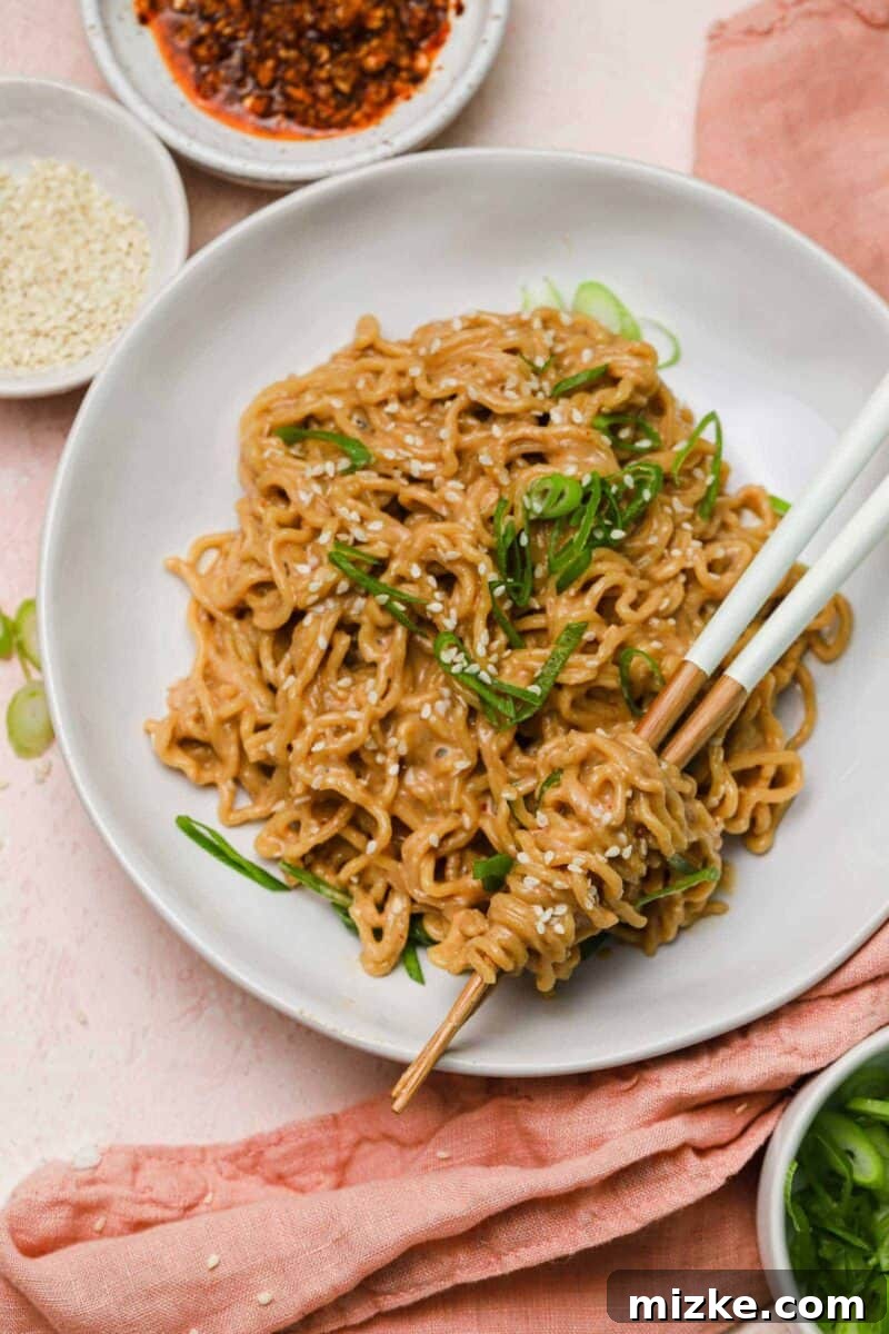 Cool Heat Peanut Sesame Noodles 2 A vibrant bowl of cold spicy peanut sesame noodles, garnished with fresh scallions and sesame seeds, ready to be enjoyed as a refreshing meal.