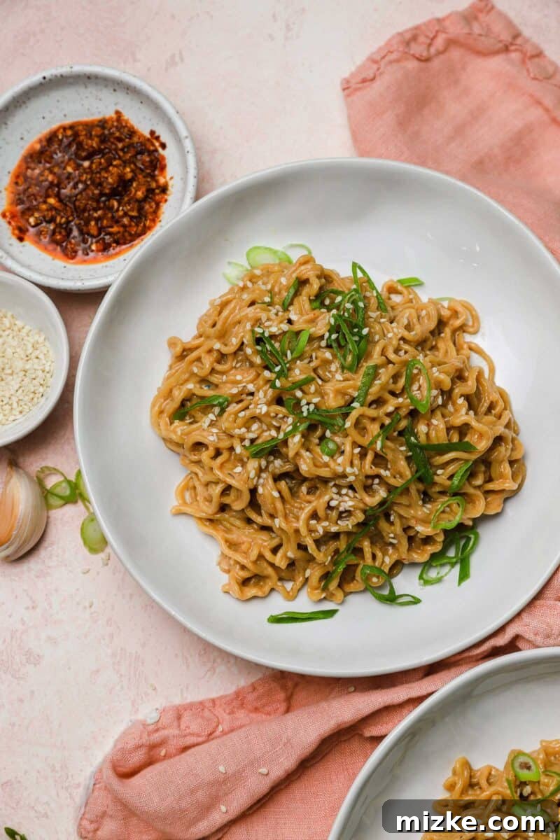 Cool Heat Peanut Sesame Noodles 4 A generous serving of cold spicy peanut sesame noodles in a bowl, ready to be tossed and served.