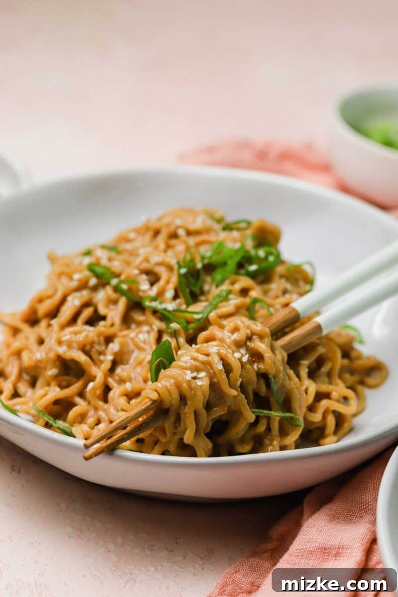 Cool Heat Peanut Sesame Noodles 5 A bowl of cold spicy peanut sesame noodles, beautifully plated with chopped scallions and extra sesame seeds for garnish.