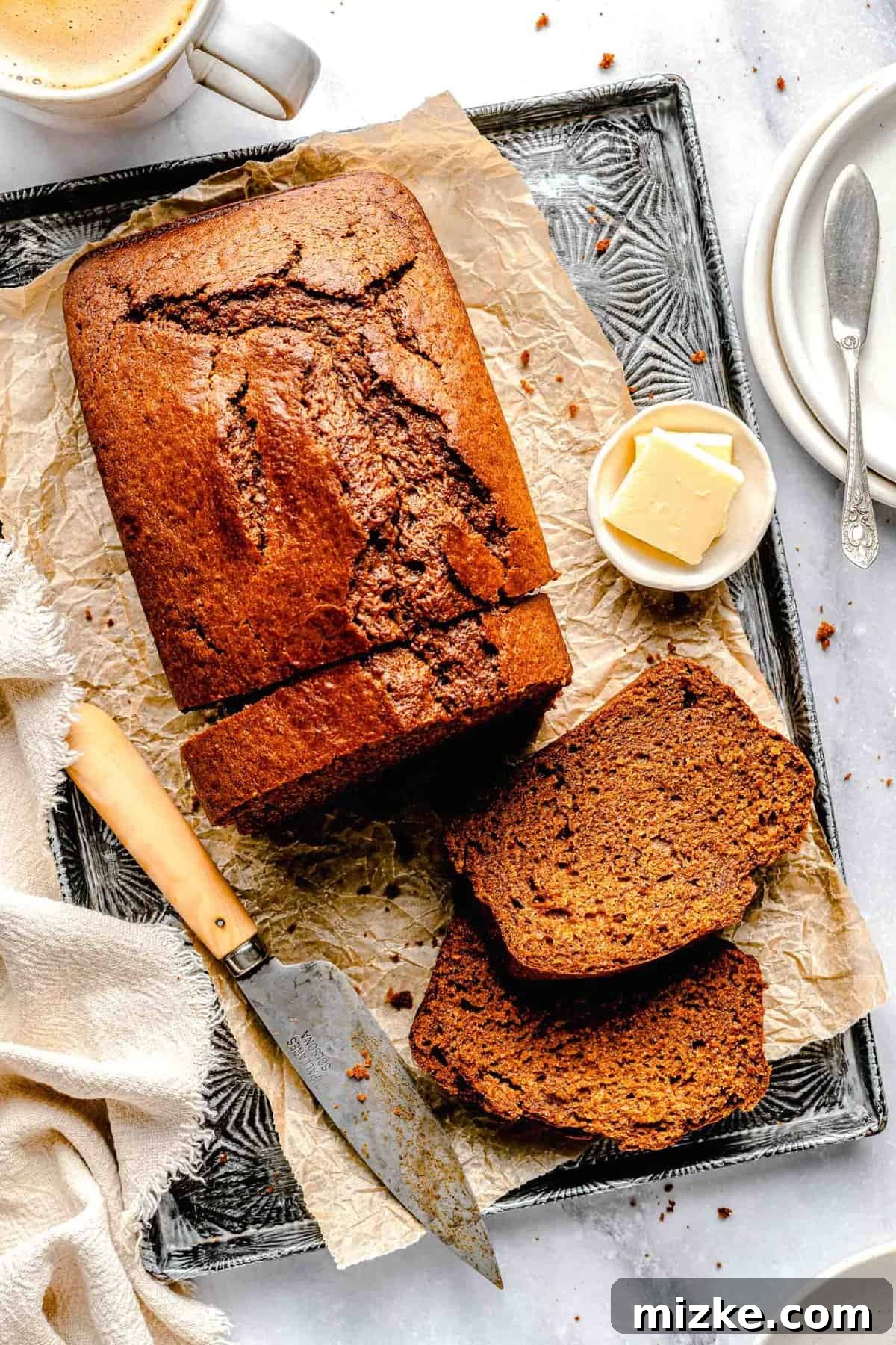 Deliciously moist sweet potato bread, expertly sliced and ready to be enjoyed. Made with mashed sweet potatoes, brown sugar, buttermilk, and pumpkin spice, it's a tender and subtly sweet treat. Overhead image of sweet potato bread cut into slices, showcasing its moist texture and golden-brown crust.