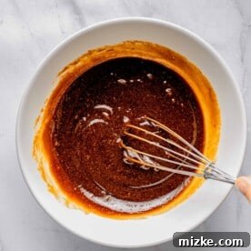 Whisking together wet ingredients for sweet potato bread.