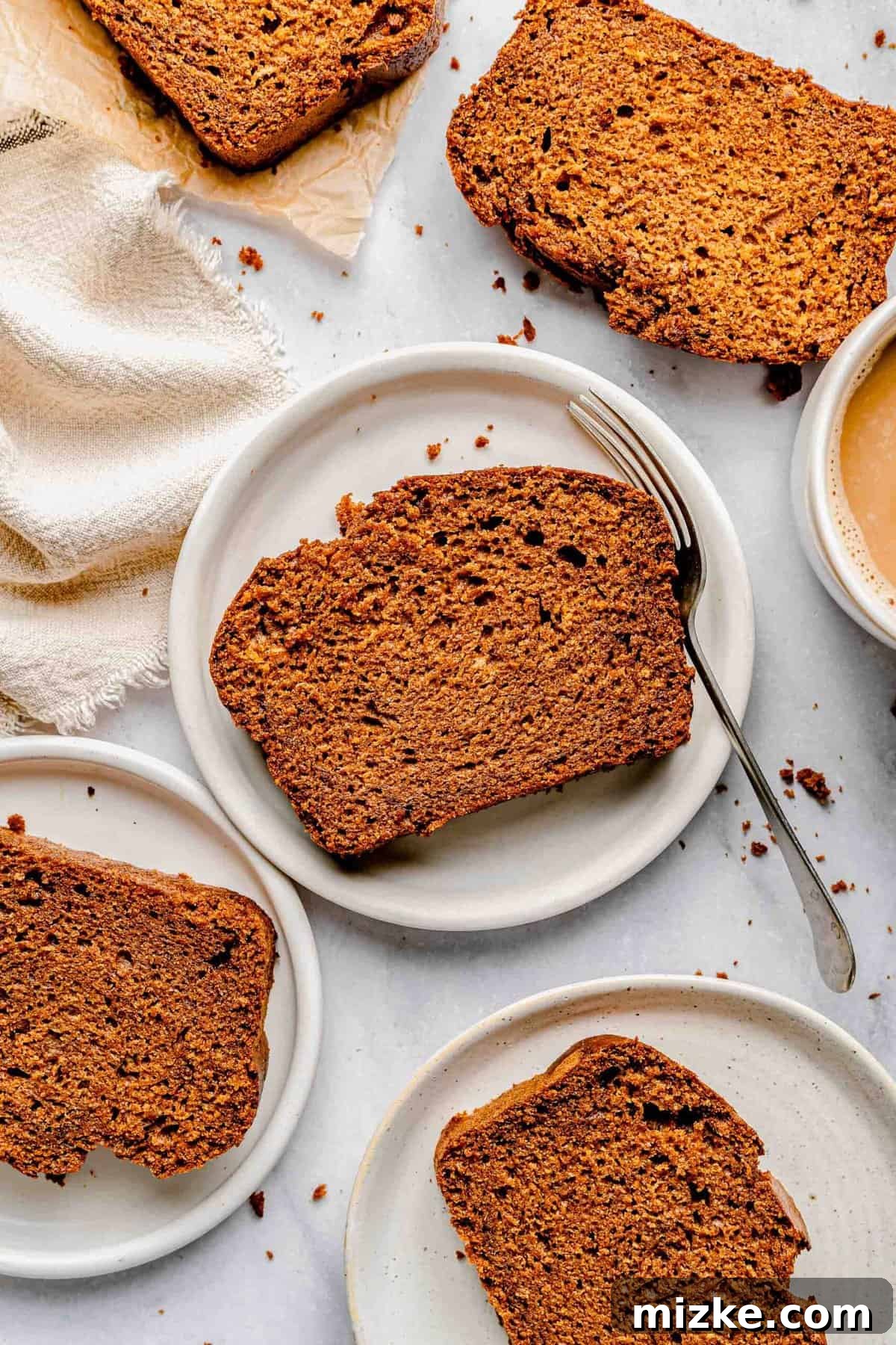 Delightfully sliced sweet potato bread, perfect for serving. This tender, moist, and subtly sweet loaf is made with mashed sweet potatoes, brown sugar, buttermilk, and pumpkin spice. Sweet potato bread sliced into individual portions and arranged on serving plates, ready to be enjoyed.